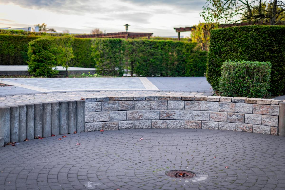 Runder Pflasterplatz mit geschwungener Sitzmauer